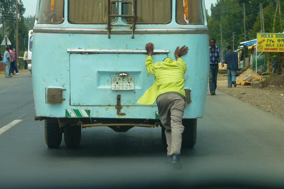 Mann schiebt Bus in Äthiopien