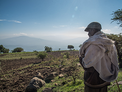 Ein Mann blickt über ein karges Feld im Hochland von Äthiopien