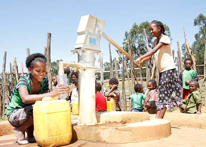 Zwei Mädchen in Äthiopien bei einem Brunnen holen Wasser