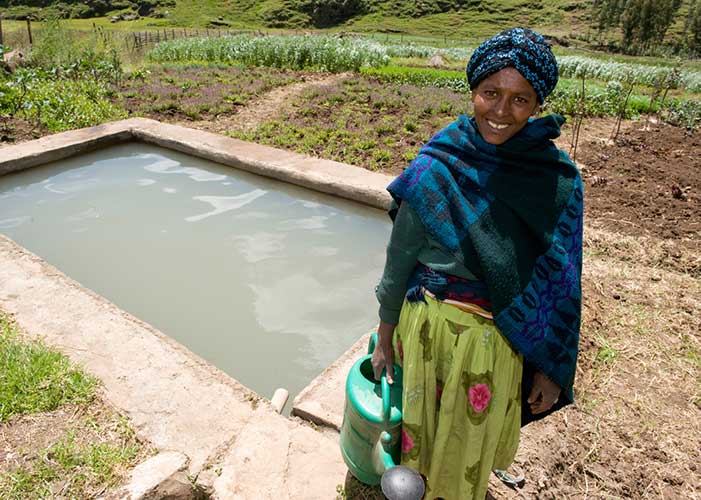 Frau vor Bewässerungsanlage von Menschen für Menschen