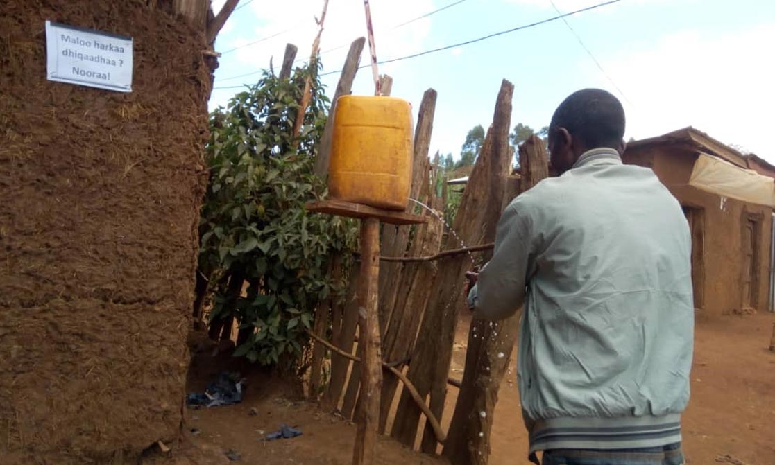Ein Mann wäscht sich in einem äthiopischen Dorf die Hände