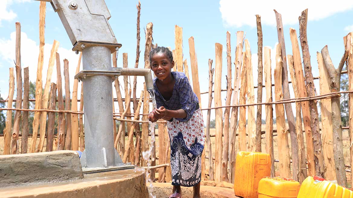 Junges Mädchen in Äthiopien pumpt Wasser aus einem sauberen Brunnen