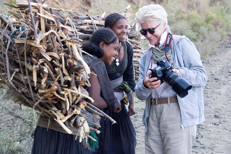 Fotografin Inge Prader zeigt zwei Mädchen in Äthiopien ihre Fotos auf der Kamera