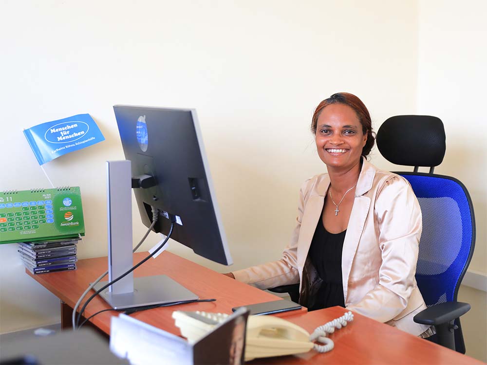 Äthiopische Mitarbeiterin Bahritu sitzt vor Computer und lächelt