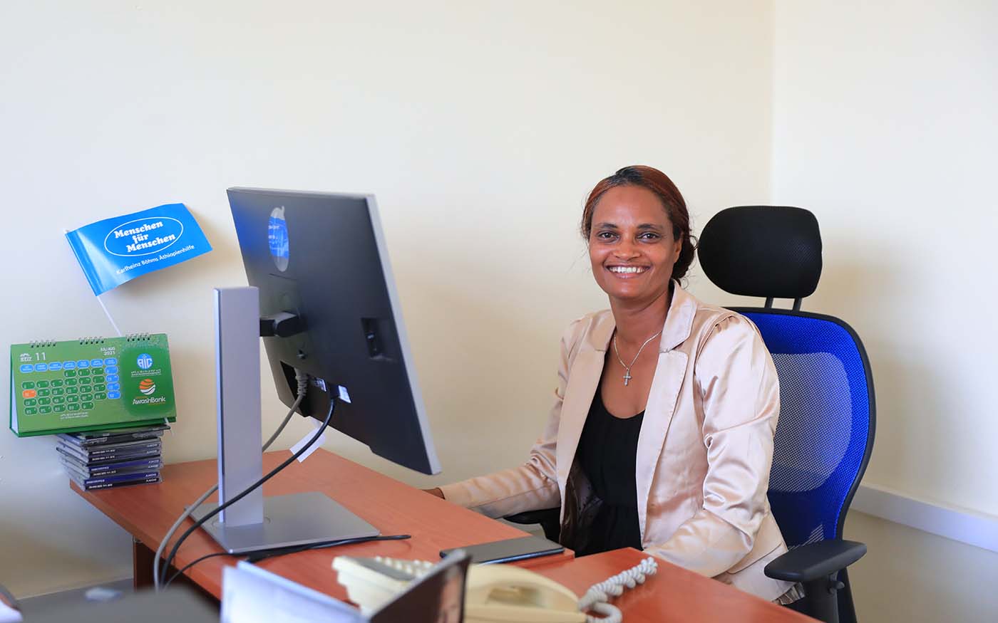 Äthiopische Mitarbeiterin Bahritu sitzt vor Computer und lächelt
