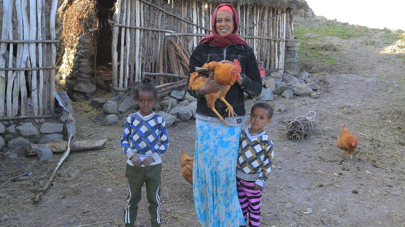 Mutter mit Huhn im Arm und ihren zwei Kindern in Äthiopien