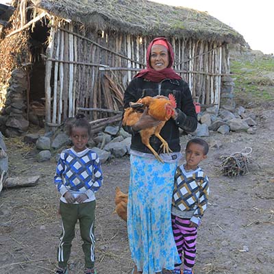 Mutter mit Huhn im Arm und ihren zwei Kindern in Äthiopien