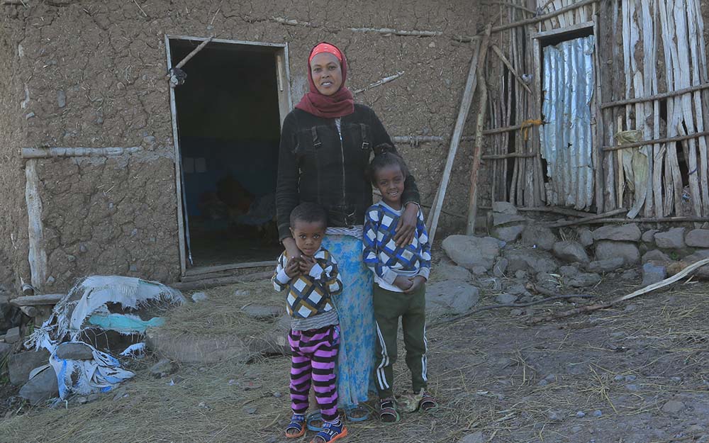Mutter mit ihren Kindern vor Hütte in Äthiopien
