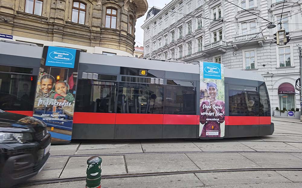 Straßenbahn in Wien mit Menschen für Menschen Werbeplakaten