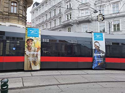 Straßenbahn in Wien mit Menschen für Menschen Werbeplakaten
