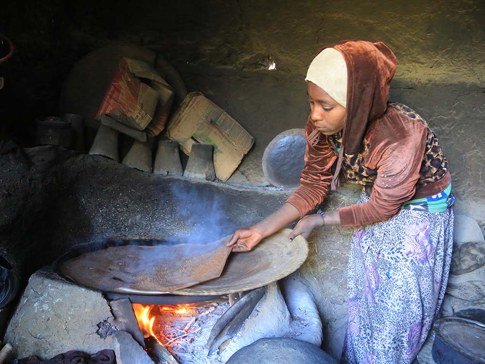 Äthiopische Frau kocht auf offenem Feuer.