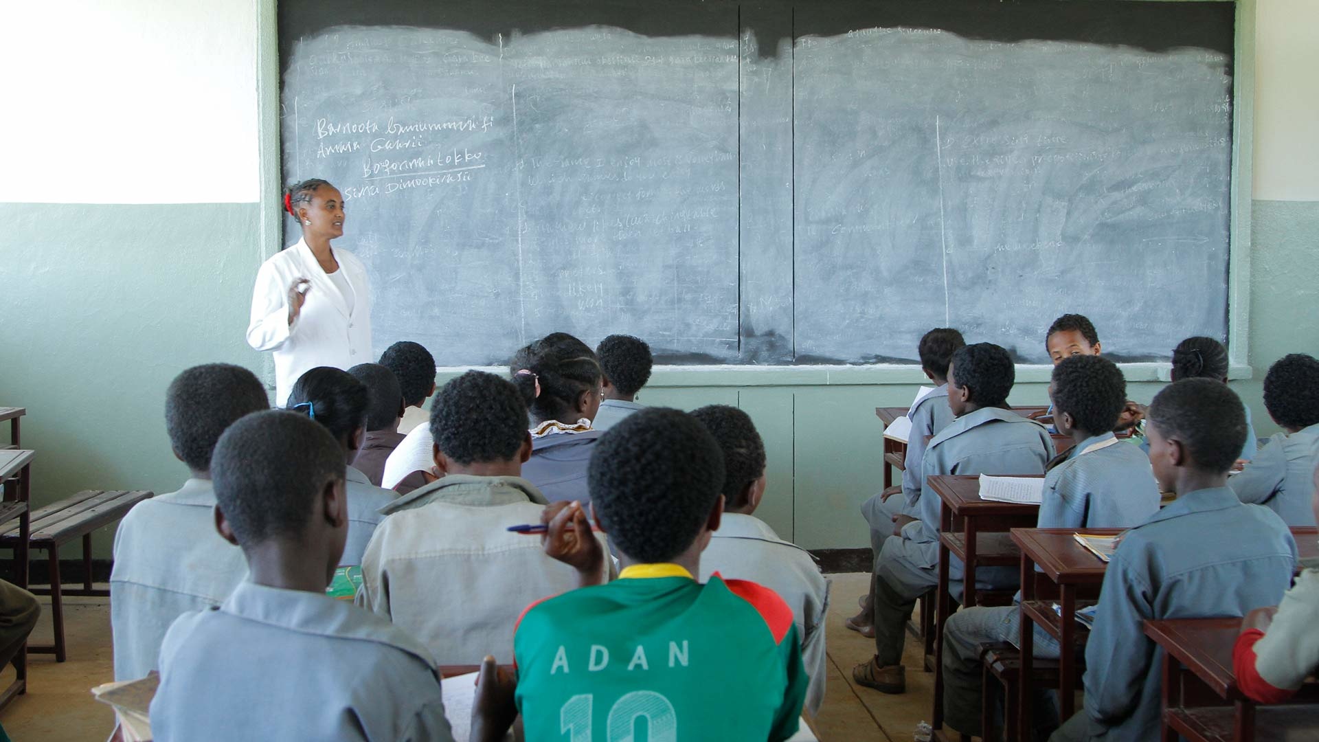 Eine Lehrerin im weißen Kittel unterichtet eine Klasse äthiopischer Schülerinnen