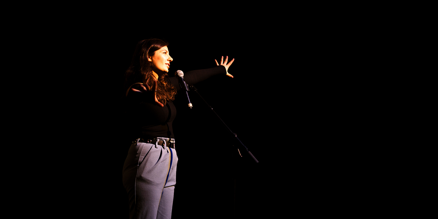 Frau bei ihrem Auftritt bei einem Poetry Slam.
