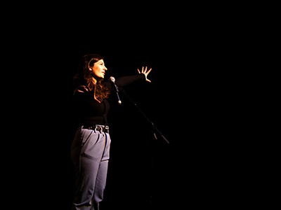 Frau bei ihrem Auftritt bei einem Poetry Slam.