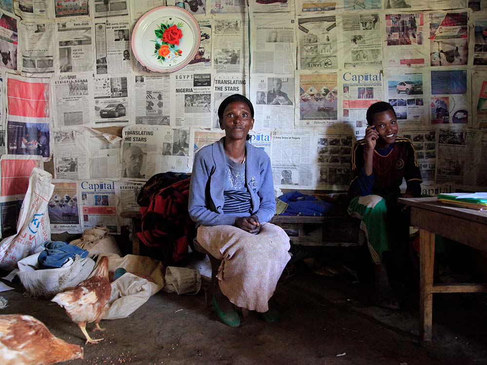 Äthiopische Frau vor Wand mit Zeitungen