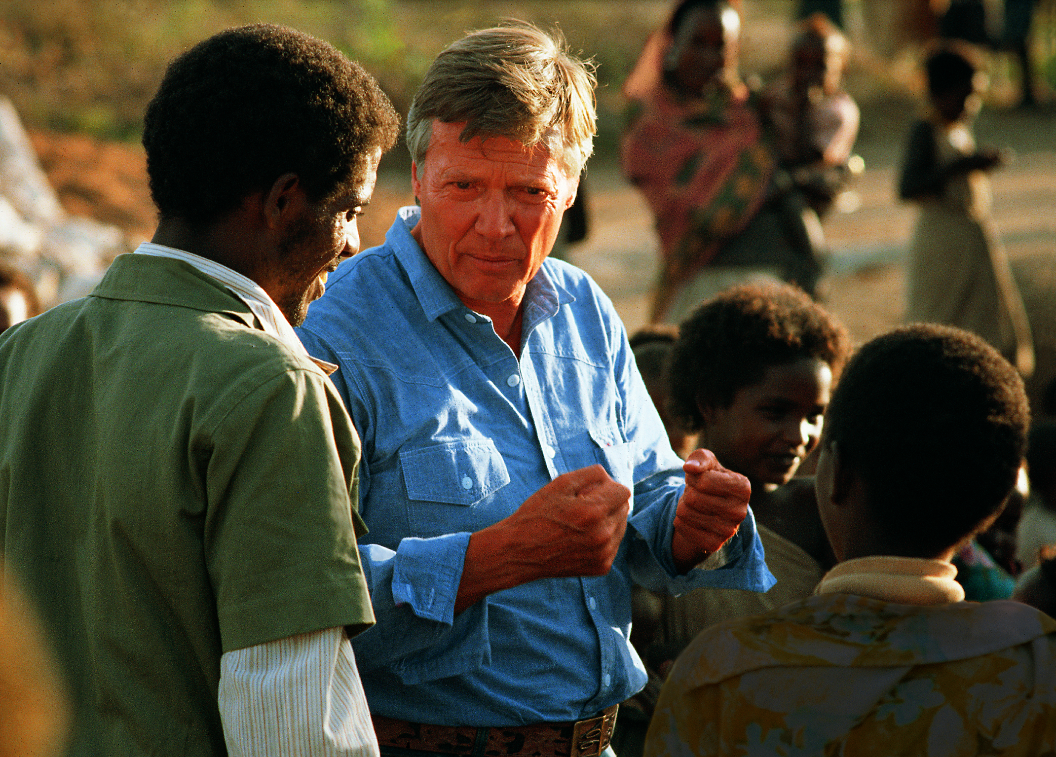 Karlheinz Böhm in Äthiopien spricht angeregt mit Personen um ihn herum.