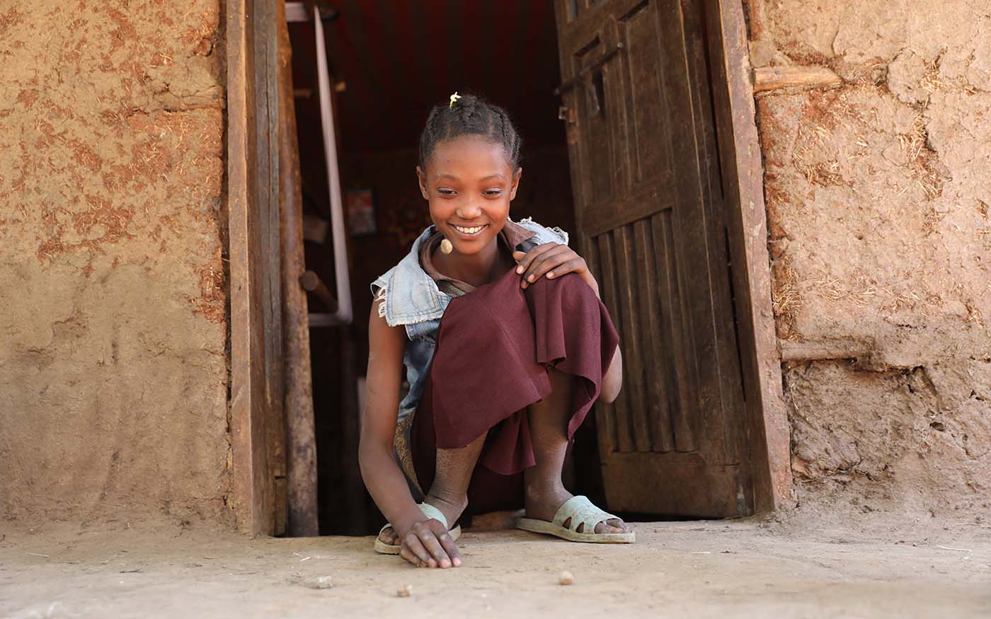 Mädchen in Äthiopien spielt ein Geschicklichkeitsspiel mit Steinen