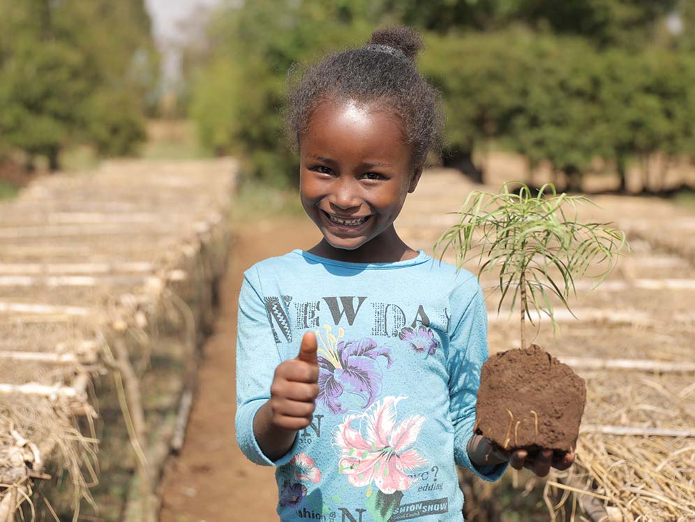 Äthiopisches Mädchen mit Baumsetzling in der Hand