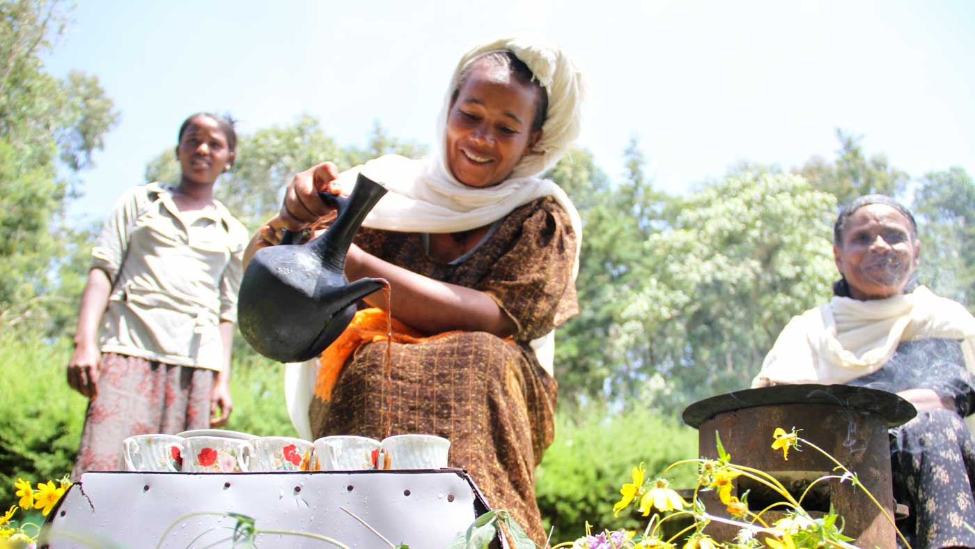 Frau in Äthiopien gießt Kaffee ein