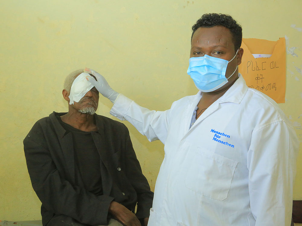 Leiter der Gesundheitsprojekte in Albuko Tegegn Fantew mit einem Patienten nach einer Augenlicht-rettenden Operation.