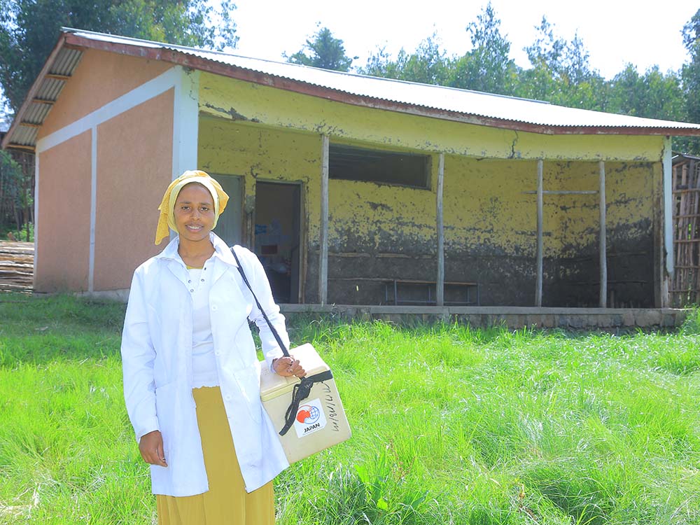 Eine Gesundheitsmitarbeiterin steht vor einer Gesundheitsstation im ländlichen Äthiopien