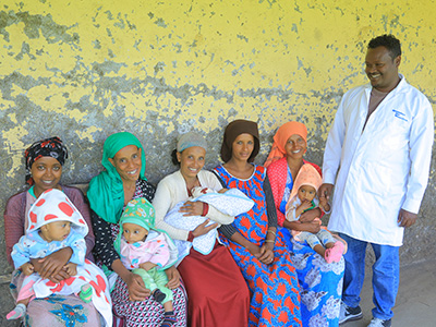 Eine Gruppe Mütter mit ihren Babys und einem Gesundheitsmitarbeiter bei einer Gesundheitsstation in Äthiopien