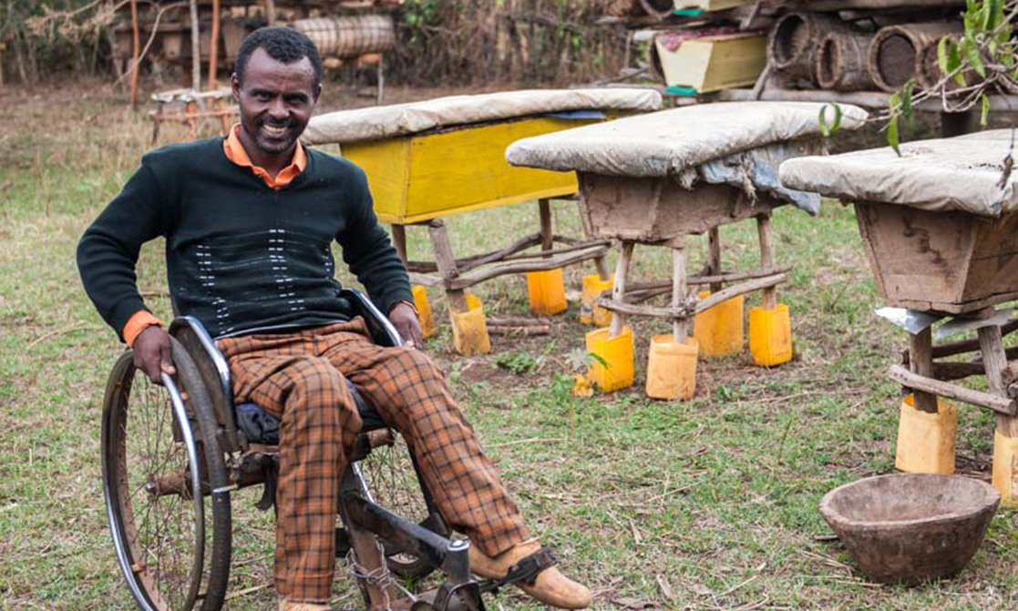 Ein äthiopischer Bienenzüchter der trotz Rollstuhl eine große Antahl Bienenstöcke hat.