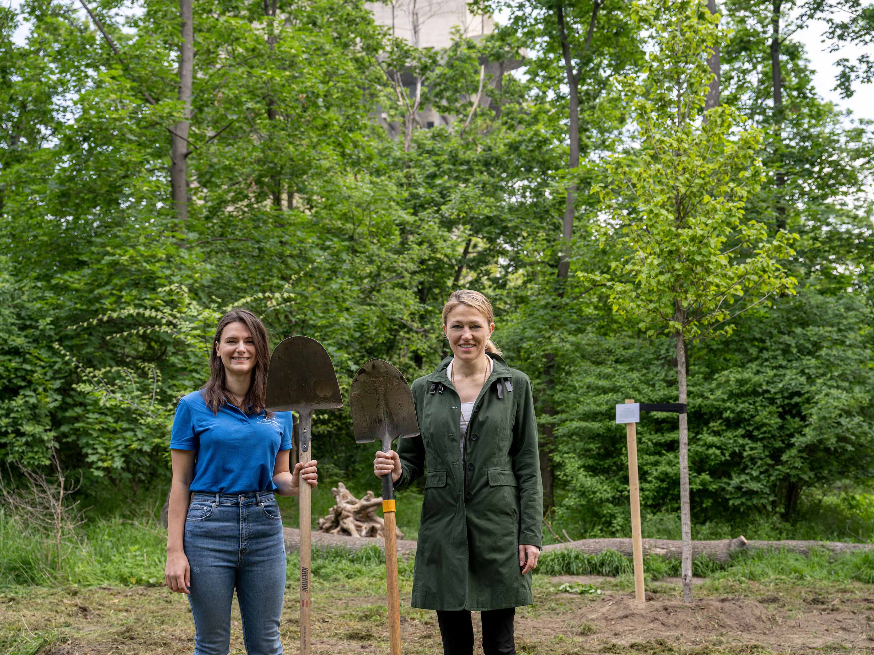 Zwei Frauen stehen vor einem Baum.