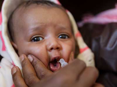 ein baby erhält eine orale impfung