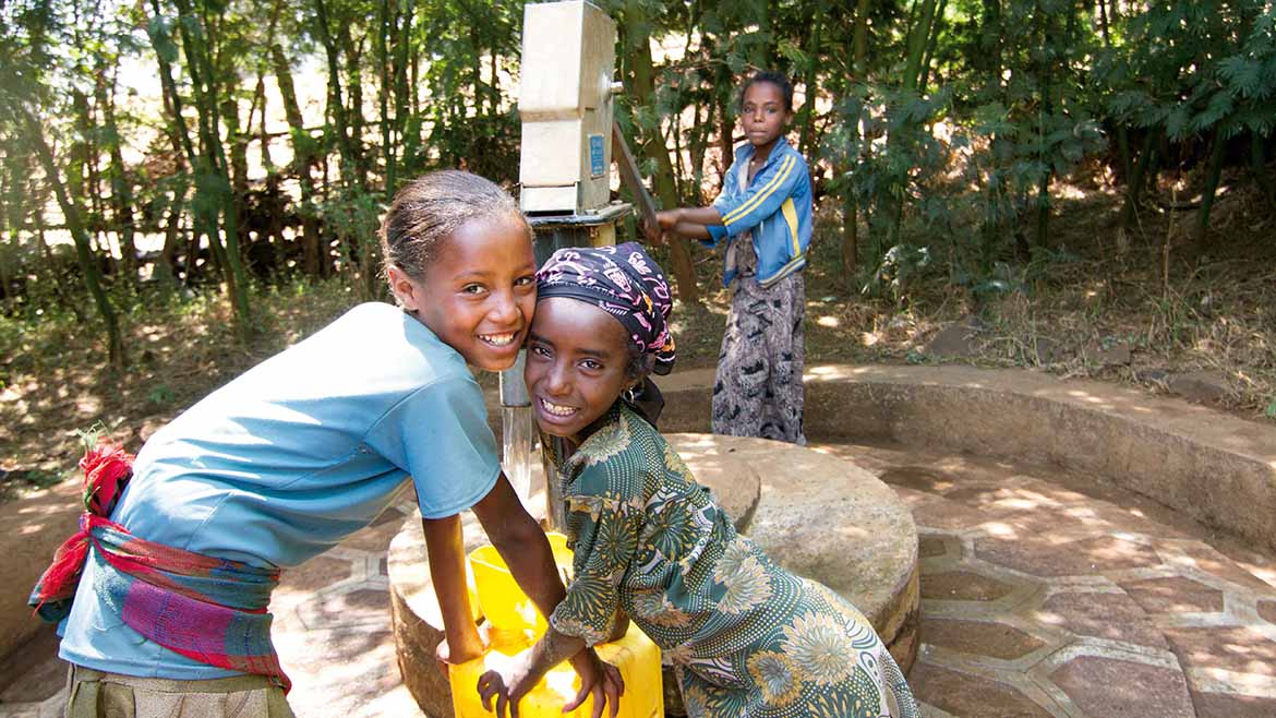 Zwei äthiopische Mädchen vor einem Brunnen.