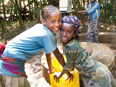 Zwei äthiopische Mädchen vor einem Brunnen .