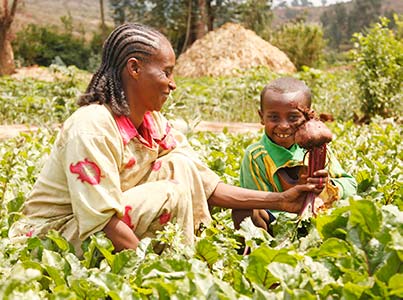 Eine Mutter mit ihrem Kind in einem Gemüsefeld