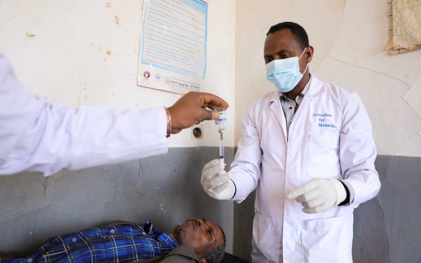 Doktor in Äthiopien mit Mundschutz und Spritze
