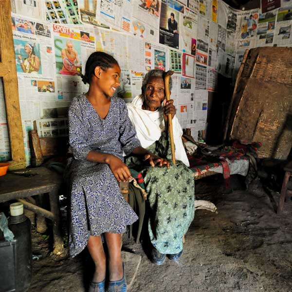 Enkelin und Oma sitzen gemeinsam auf einer Bank in Äthiopien