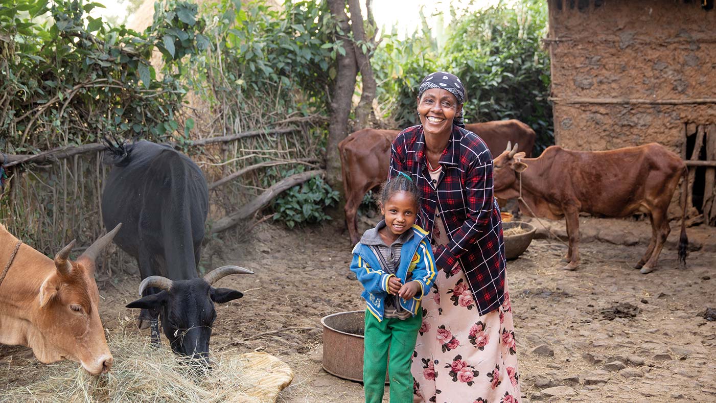 Mutter und Tochter in Äthiopien vor ihrem Haus mit Kühen