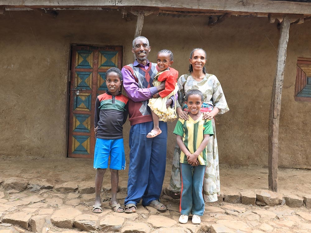 Eine Familie steht vor einem Haus.