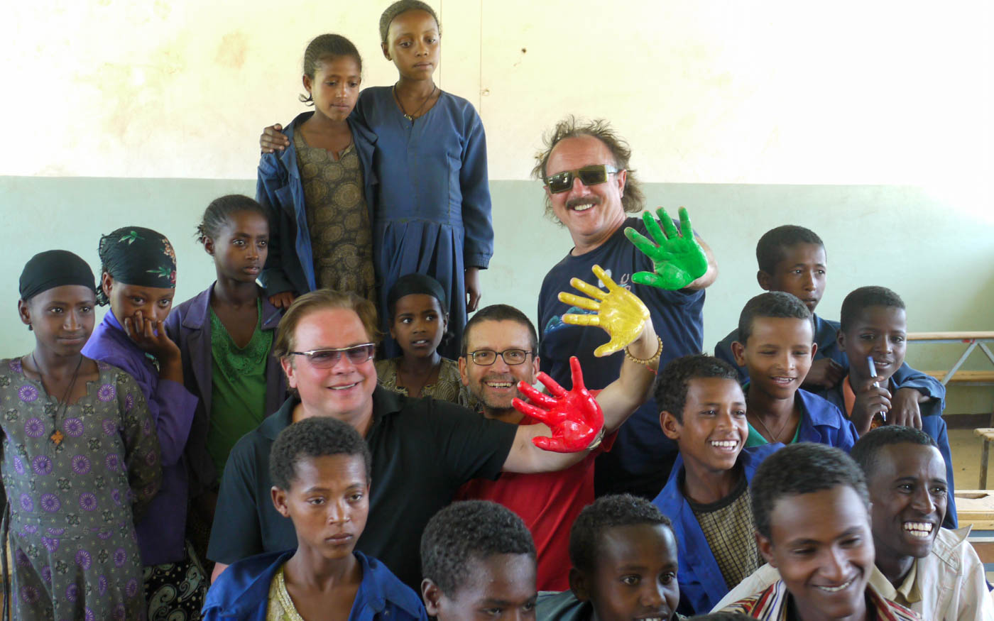 Mitglieder von Opus mit bunt angemalten Händen umringt von äthiopischen Kindern