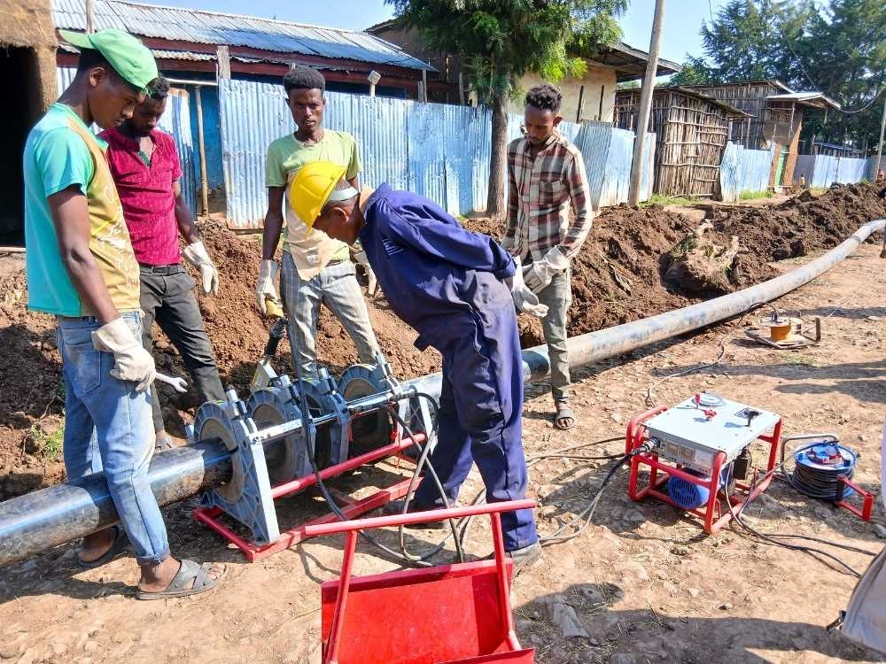 Dorfbewohner:innen aus Busa helfen beim Verlegen von Rohren für das geplante Wasserversorgungssystem.