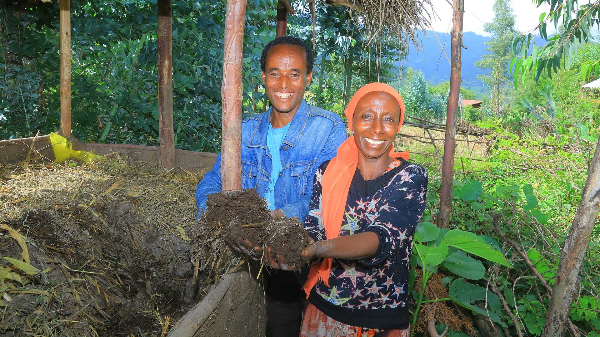 Eine Frau und ein Mann entnehmen in ihrem Garten frische Erde aus einem Wurmbeet.