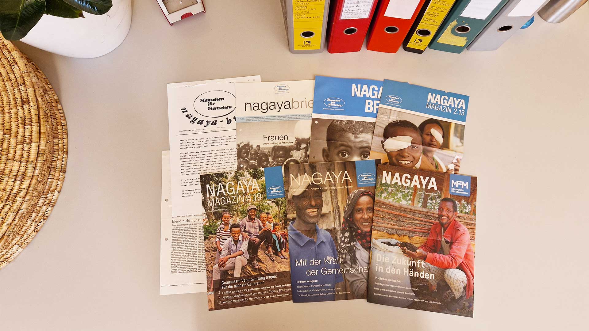 Auf dem Tisch liegen einige Ausgaben des Nagaya-Magazins von Menschen für Menschen aus den letzten Jahren.