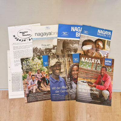 Auf dem Tisch liegen einige Ausgaben des Nagaya-Magazins von Menschen für Menschen aus den letzten Jahren.