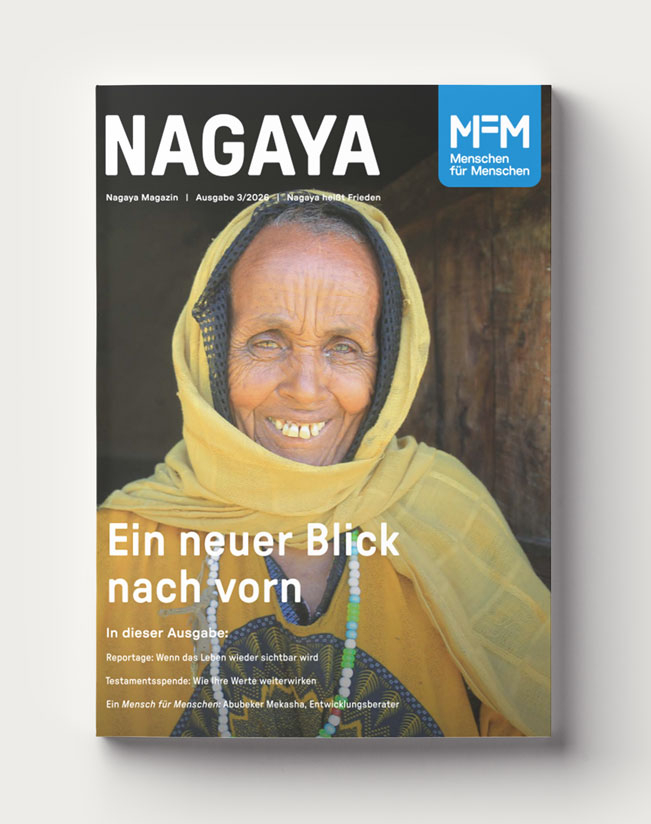 Das Cover des Nagaya-Magazins, Ausgabe 3/2026, zeigt eine ältere Frau, die sich lächelnd an einen Türstock lehnt und direkt in die Kamera blickt.
