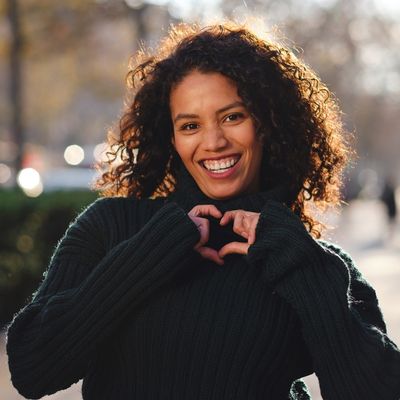 Eine Frau formt mit ihren Händen ein Herz.