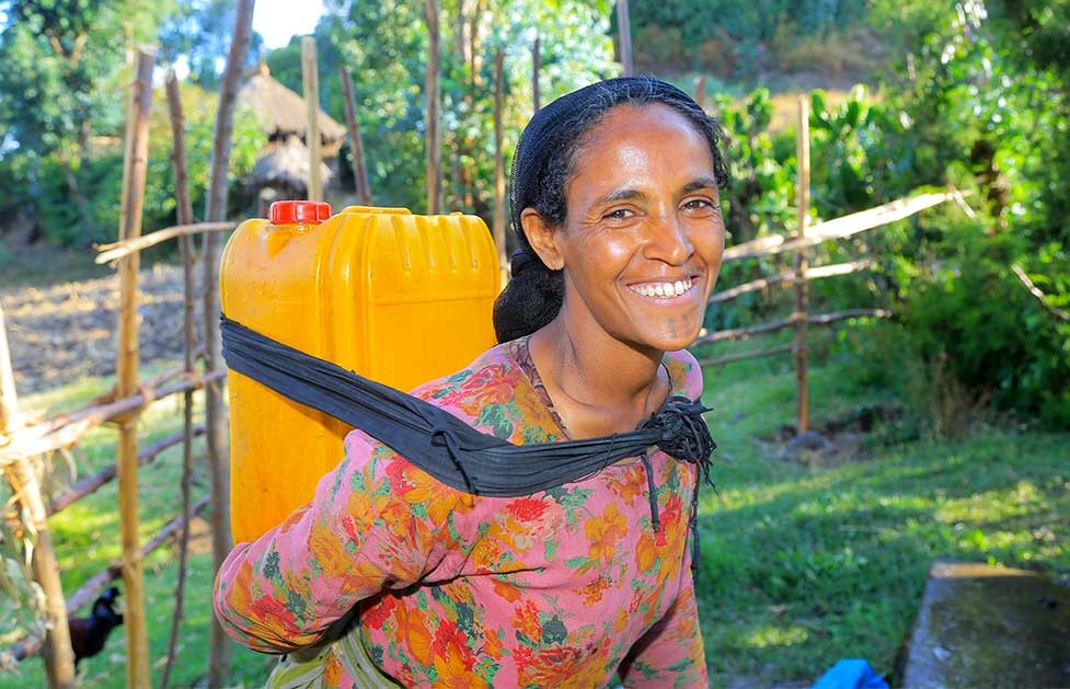 Abebech, fünffache Mutter aus Albuko, trägt einen 20-Liter-Wasserkanister auf ihrem Rücken.