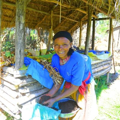 Eine Frau entnimmt aus einem Sack kompostierte Erde.