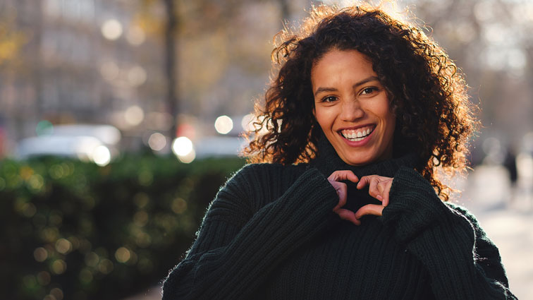 Eine Frau formt mit ihren Händen ein Herz.