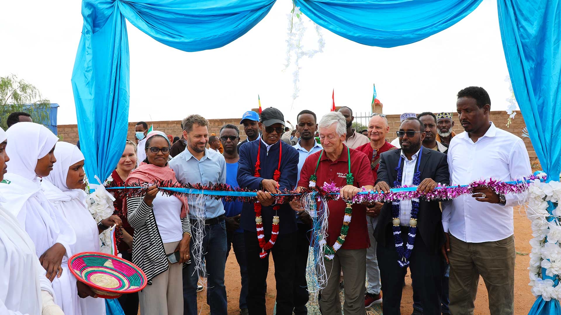 Peter Krasser schneidet zur feierlichen Eröffnung der Schule symbolisch ein Band durch.