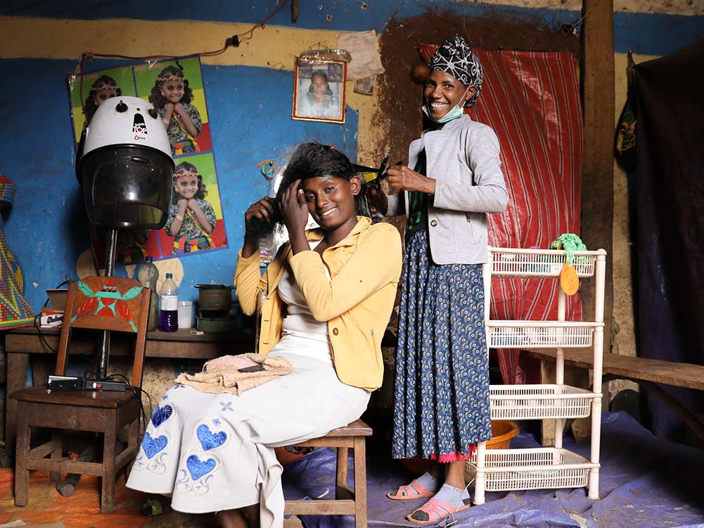 Friseurin in Äthiopien schneidet Haare einer Kundin