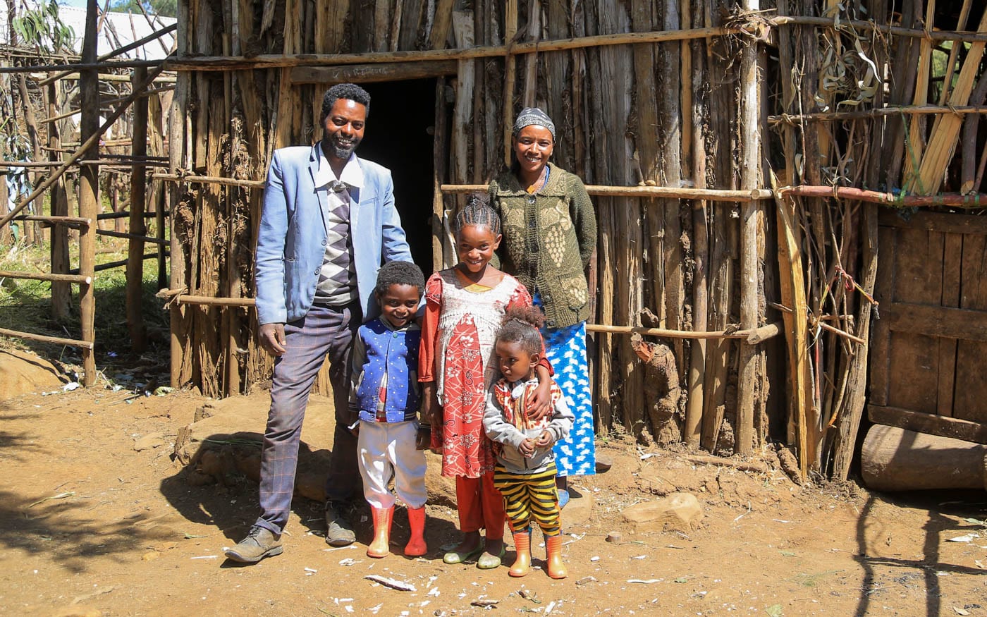 Familienvater Lechisa mit seiner Familie vor seinem neuen Holzhaus in äthiopien