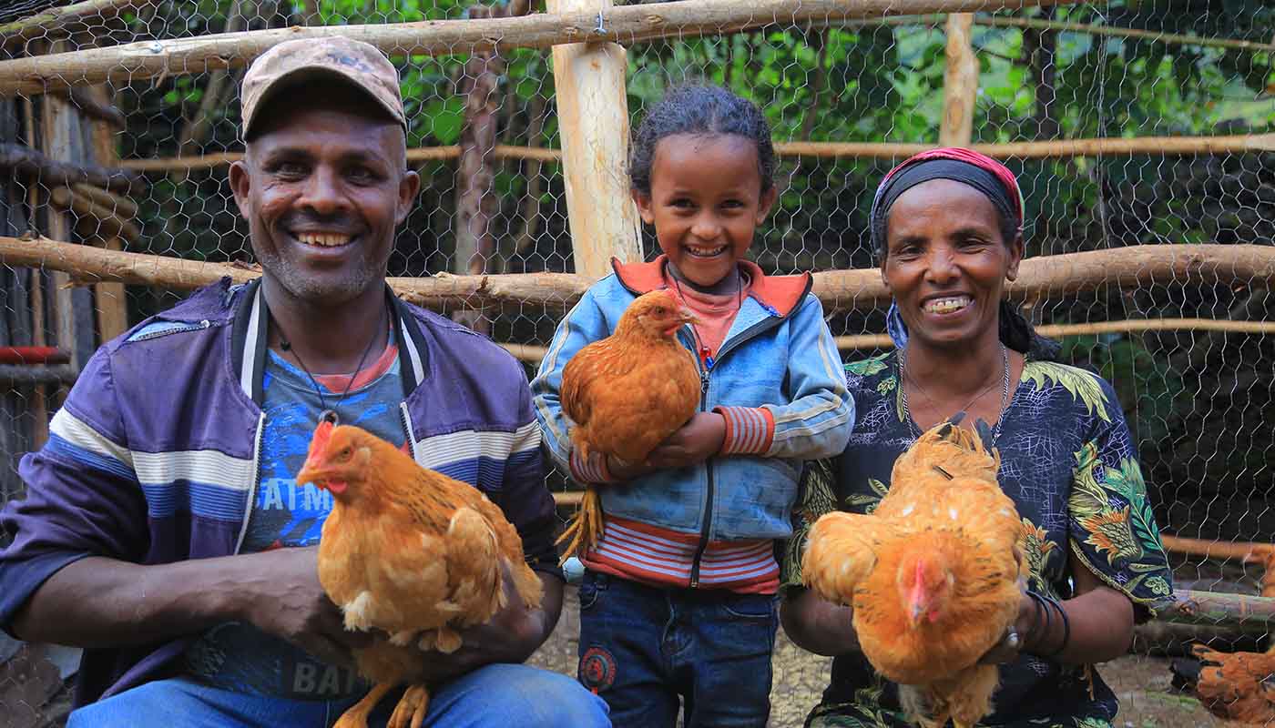 Äthiopische Familie, die Hühnern in den Händen hält und freudig lacht.